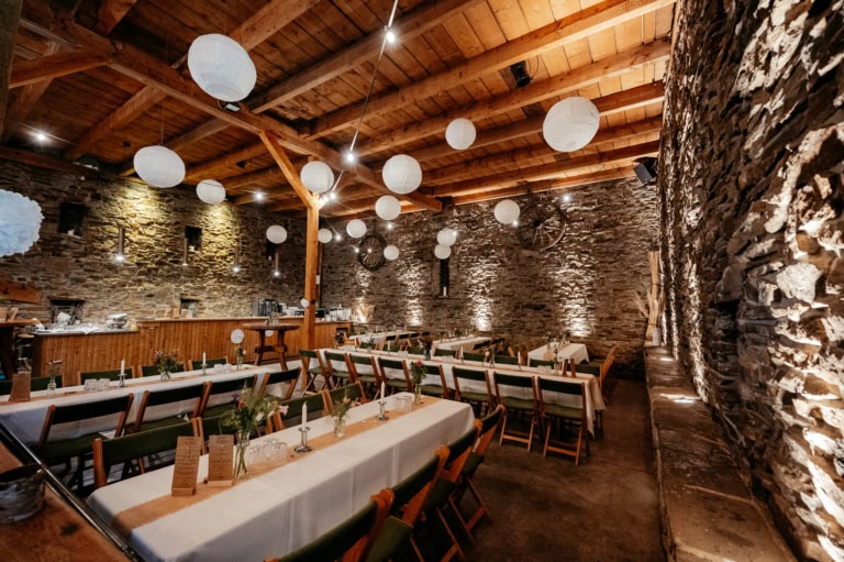 Innenraum mit Steinen, Holz und warmem Licht für Hochzeiten und Feiern.